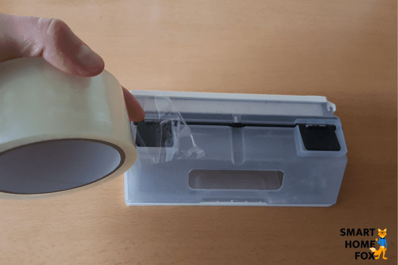 Ein Abzugsloch des Staubbehälters des Ecovacs Deebot N8 PRO+ wird mit Klebeband abgeklebt.